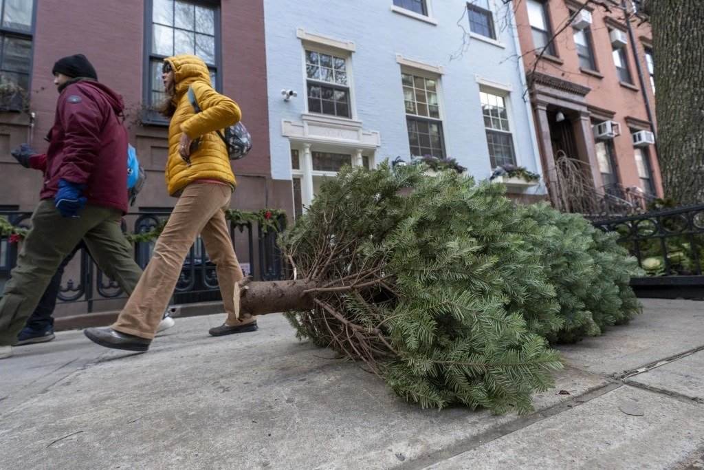 Personas caminan carca de arboles de Navidad este martes, en Greenwich Village New, Nueva York (Estados Unidos). EFE/ Angel Colmenares